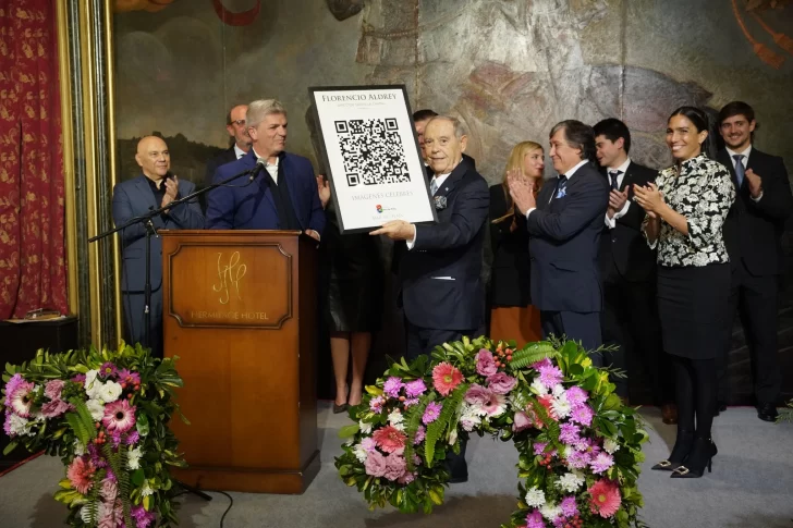  Aldrey levantó el cuadro con el QR de sus fotos. Obsequio de Canal 8. Le entregaron el periodista Daniel Alvarez y la vicepresidenta Mariela Tévez, junto a Jorge Pérez, propietario del canal. Raúl Olmos también los acompañó. FOTO: MARCELO ARDUIN / LA CAPITAL DE MAR DEL PLATA