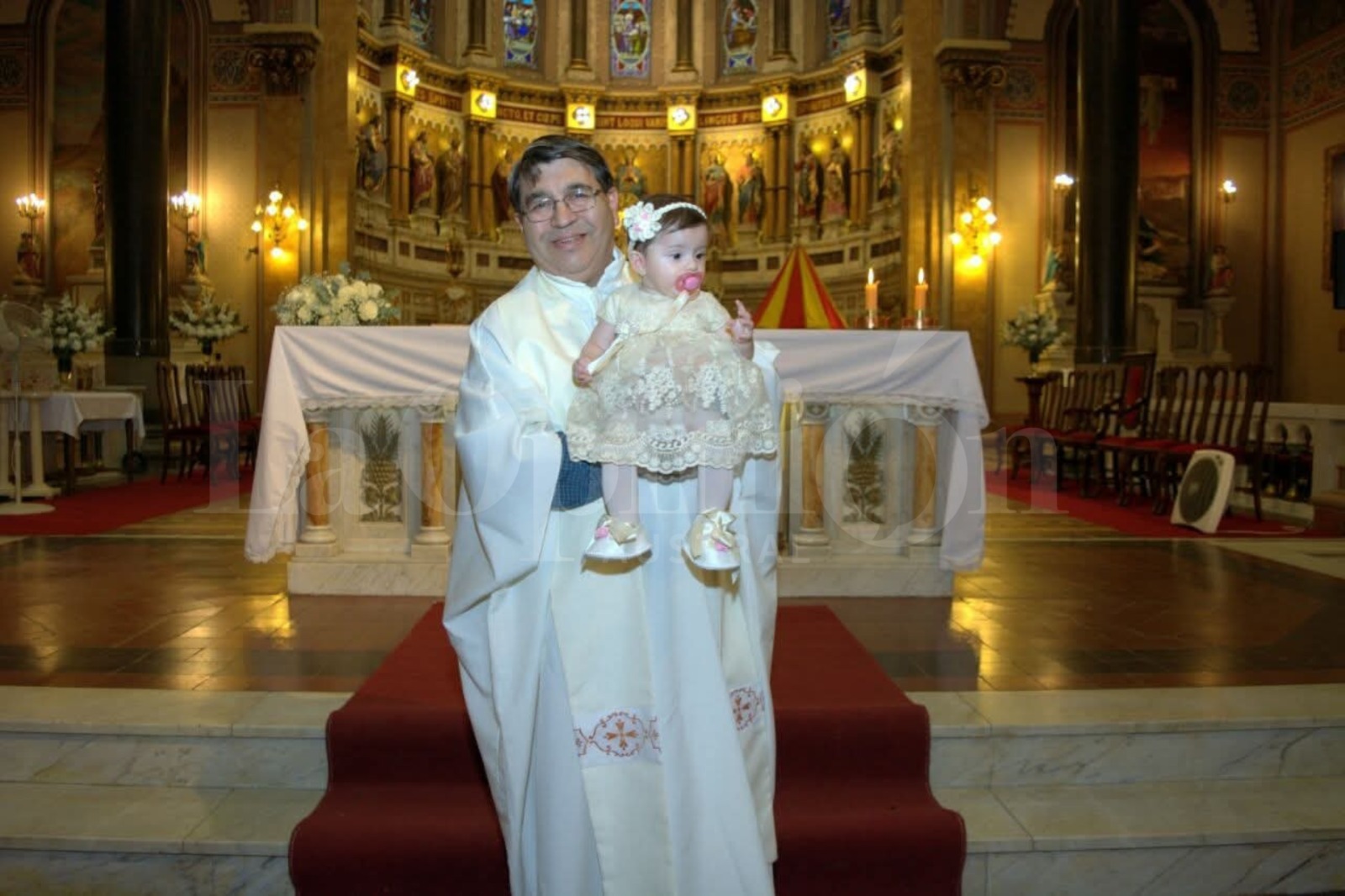  El padre Sergio Soto y Malú, su sobrina nieta, en el día de su bautismo.