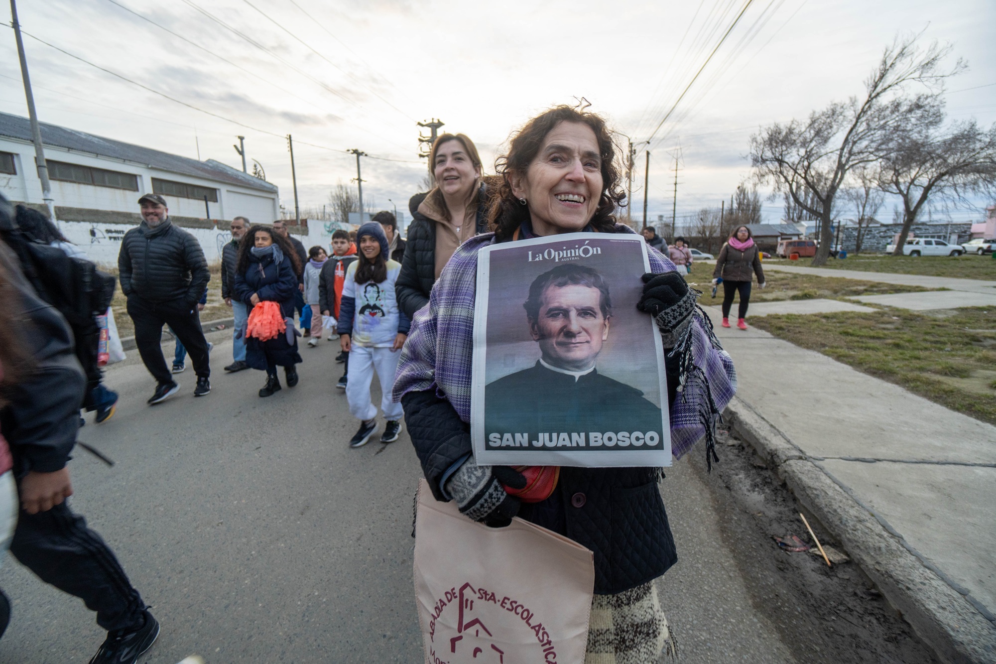  Belén Roldán en la procesión y con el póster de Don Bosco. FOTO: LEANDRO FRANCO/ LA OPINIÓN AUSTRAL