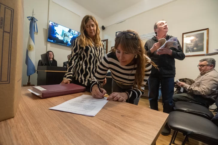  Marcela Padrón, una de las apoderadas, firmando el acta de la audiencia. FOTO: LEANDRO FRANCO/ LA OPINIÓN AUSTRAL