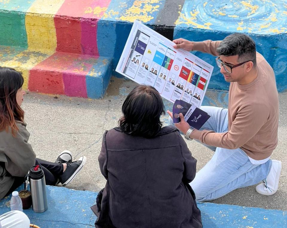  El candidato de La LLA explicando el uso de la Boleta Única de Papel a los vecinos.