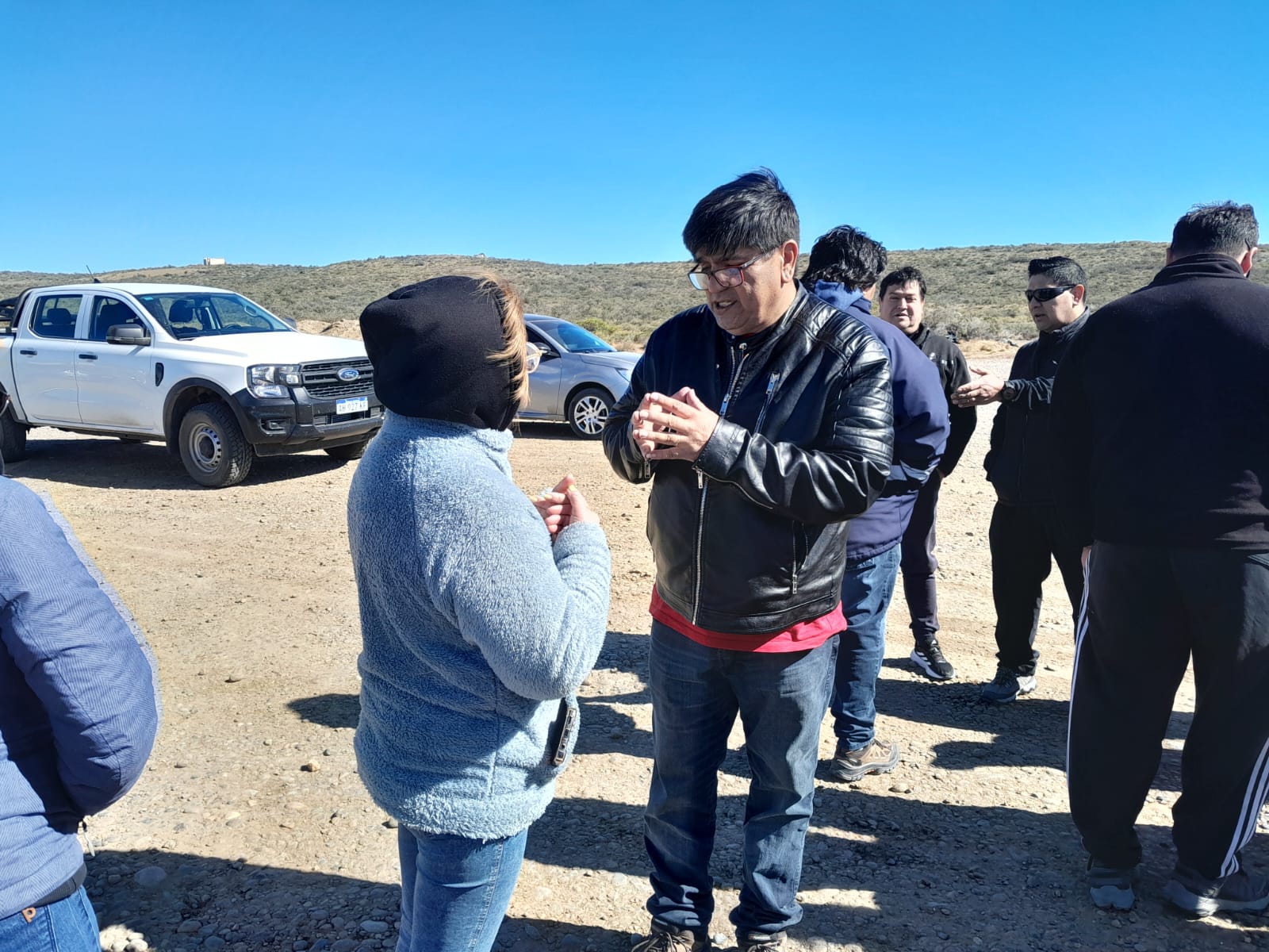  Daniel Barrera de SPSE le explica la situación de escasez del agua a los vecinos en el cargadero del barrio Bicentenario.