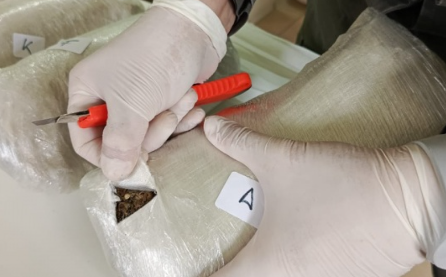  Un agente con un cutter revisando uno de los paquetes. FOTO: GENDARMERÍA NACIONAL