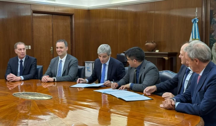  Luis Caputo y Claudio Vidal, en el momento de la firma de la reducción de retenciones al crudo convencional.