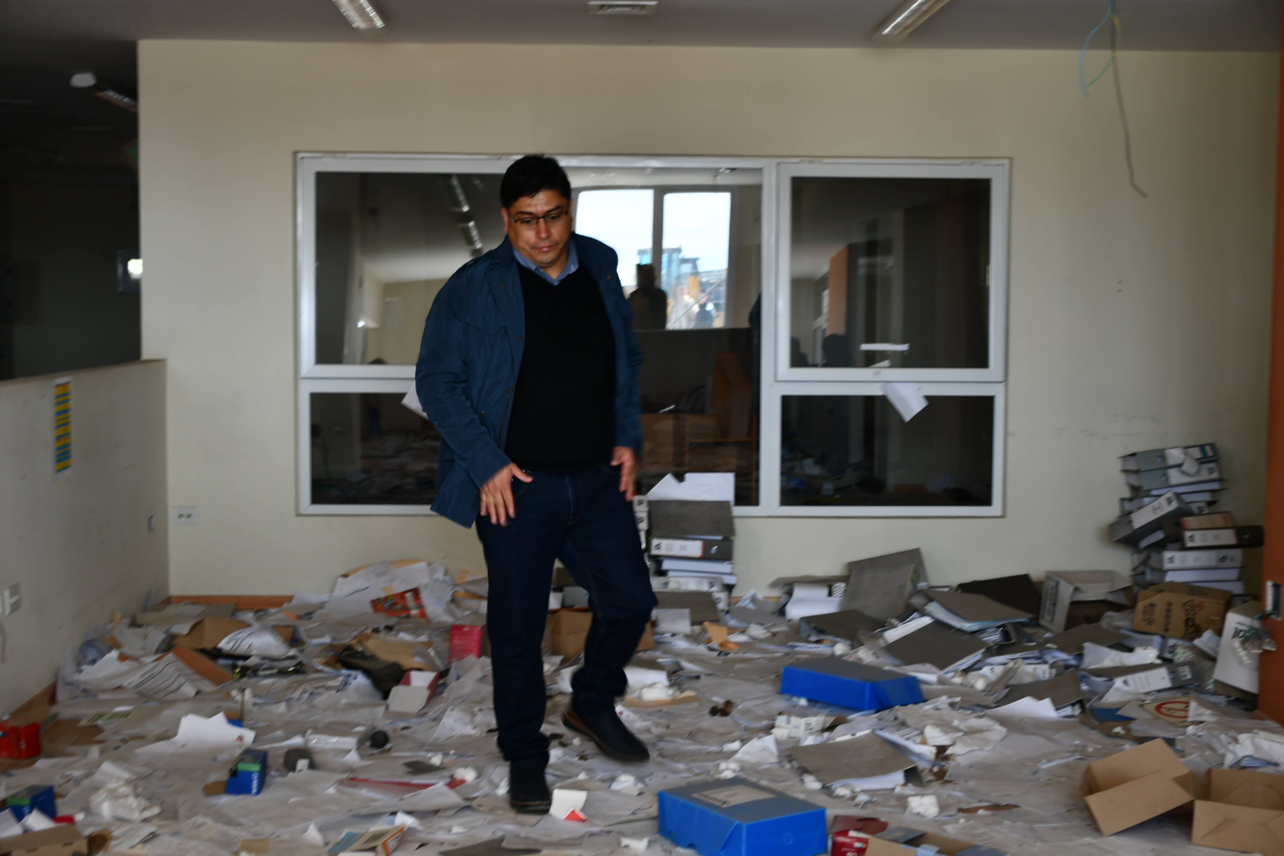  El gobernador Claudio Vidal observa, asombrado, al enorme cantidad de papeles desparrramados en el piso, que encontraron al ingresar a las instalaciones de Austral Construcciones. FOTO: JUAN PALACIOS/LA OPINIÓN AUSTRAL