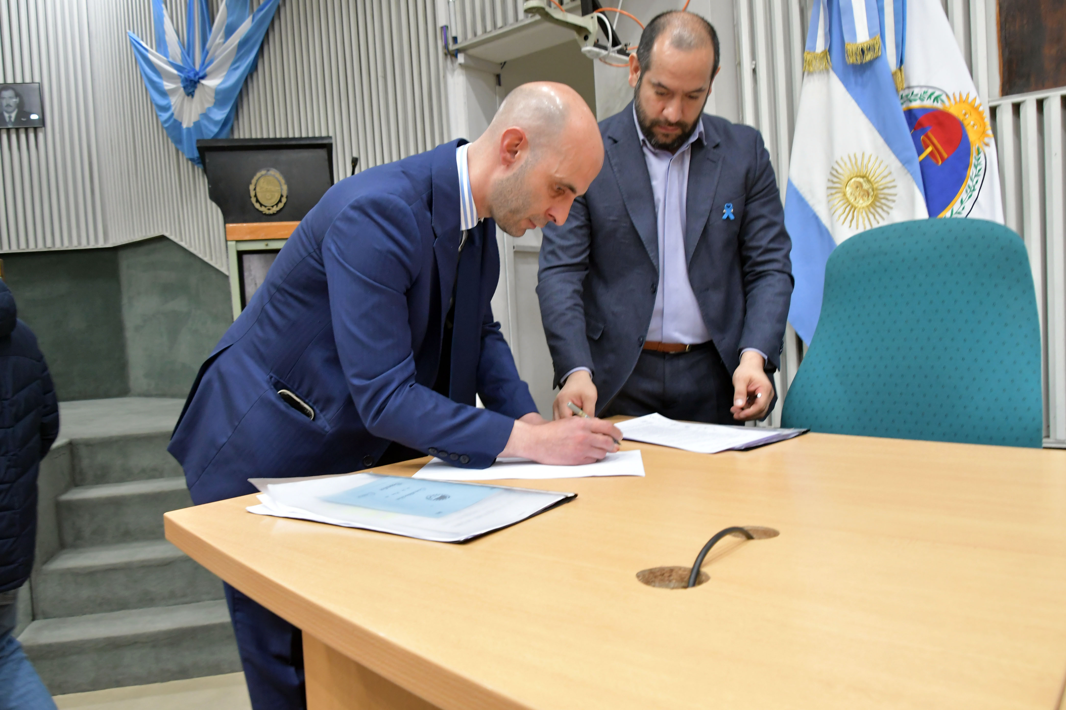  Fernando Basanta firma el veredicto de la Sala Juzgadora que lo eximió de culpas en el juicio político en su contra, ante la mirada de Diego Castro, secretario general de la Legislatura. FOTO: JOSÉ SILVA / LA OPINIÓN AUSTRAL.