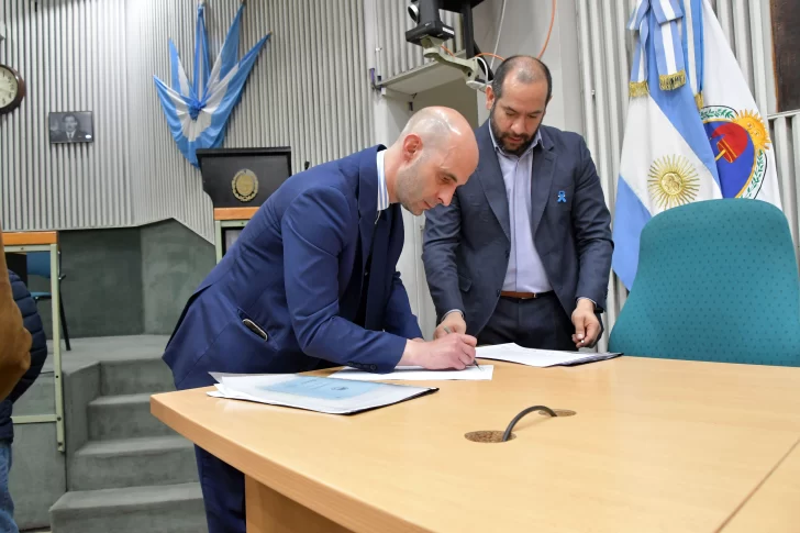  Fernando Basanta firma el veredicto de la Sala Juzgadora que lo eximió de culpas en el juicio político en su contra, ante la mirada de Diego Castro, secretario general de la Legislatura. FOTO: JOSÉ SILVA / LA OPINIÓN AUSTRAL.