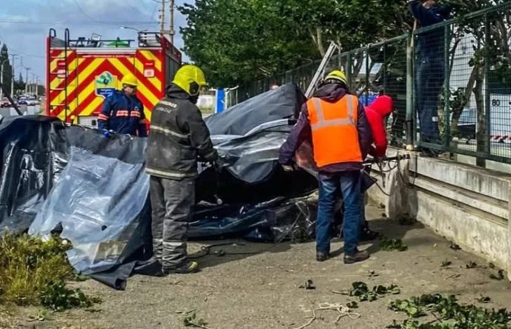  Bomberos junto a la carpa que había cedido a las fuertes ráfagas. FOTO: POLICÍA SANTA CRUZ