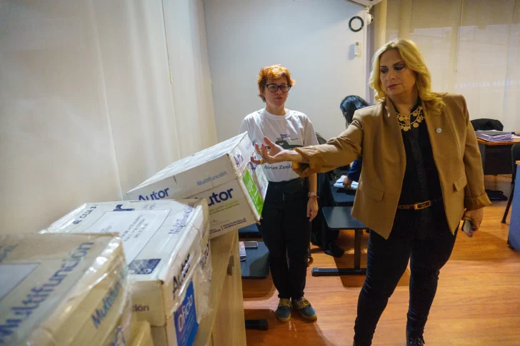  La querellante Valeria Carreras sosteniendo una de las cajas vacías. FOTO: LEANDRO FRANCO/ LA OPINIÓN AUSTRAL