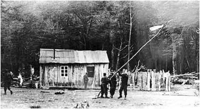  Argentinos levantando la bandera junto a una cabaña en el Lago del Desierto durante el conflicto con Chile.